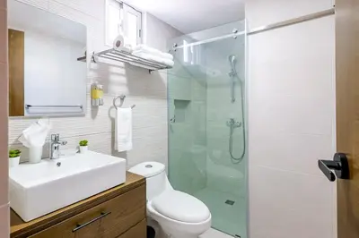 a bathroom with a sink and a glass shower at Spacious, 3BD City Center Apt in Santo Domingo