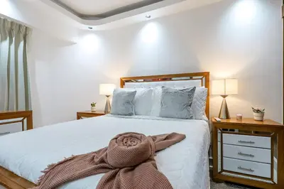 a bedroom with a bed with a blanket on it at Spacious, 3BD City Center Apt in Santo Domingo