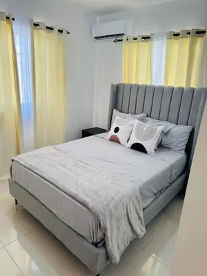 a bedroom with a large bed with yellow curtains at Welcome Home 2 in Boca Canasta