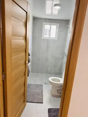 a bathroom with a toilet and a window at Welcome Home 2 in Boca Canasta