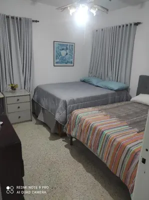 a bedroom with two beds and a dresser at Sweet beach apartment in San Felipe de Puerto Plata