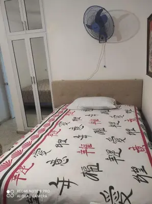 a bed with chinese writing on it with a fan at Sweet beach apartment in San Felipe de Puerto Plata