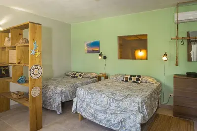 a bedroom with two beds and a dresser and shelves at Lux Garden Loft close to Beach, Kite-school in Cabarete