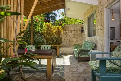 an outdoor patio with a wooden table and chairs at Lux Garden Loft close to Beach, Kite-school in Cabarete