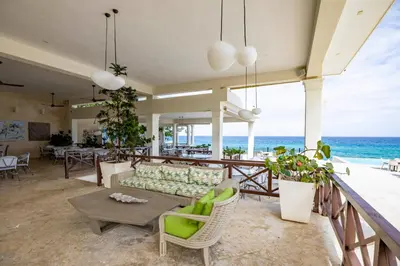 a living room with a couch and a table and the ocean at Sosua Ocean Village Villa 24 in Sosúa