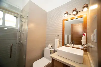 a bathroom with a sink and a toilet and a mirror at 2 bedrooms Villa 16 at Villas Tisu in Sosúa