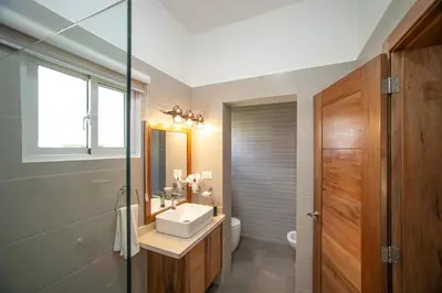 a bathroom with a sink and a toilet and a mirror at 2 bedrooms Villa 16 at Villas Tisu in Sosúa