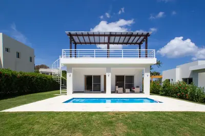 a villa with a swimming pool in front of a house at 2 bedrooms Villa 16 at Villas Tisu in Sosúa