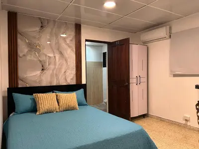 a bedroom with a blue bed and a painting on the wall at Dominico Colonial in Santo Domingo