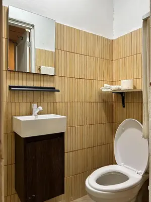 a bathroom with a toilet and a sink and a mirror at Dominico Colonial in Santo Domingo
