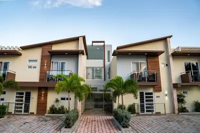 an apartment building with palm trees in front of it at La Isla Royal - Marea Estelar in Miches