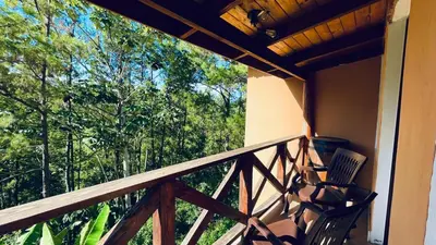 a balcony with a chair and a view of trees at Luxury Villa Heated Pool, Firepit & Pool Table in Arroyo Frío