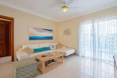 a living room with a couch and a table at Stylish Punta Cana Apartment - Eden Caribe in Punta Cana