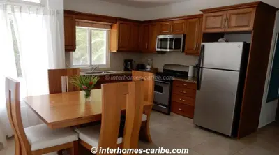 a kitchen with a wooden table and a refrigerator at 2-bed Villa with private pool at CASA LINDA in Sosúa