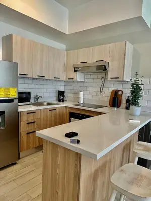 a kitchen with wooden cabinets and stainless steel appliances at Swim-Up Paradise, AirBB for more info in Punta Cana
