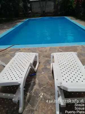 a white bench next to a swimming pool at 4 bedroom villa, private pool, ocean view, security in Sosúa
