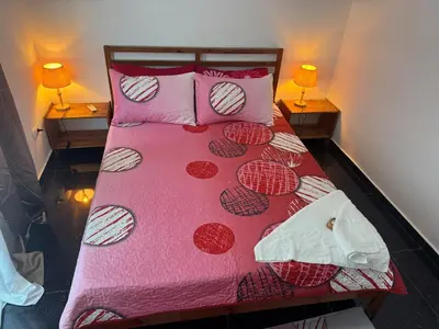 a bed with a pink comforter and two lamps at Modern 3-Bedroom Apartment with Pool in Boca Chica