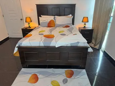a bedroom with a bed with two lamps on two tables at Modern 3-Bedroom Apartment with Pool in Boca Chica