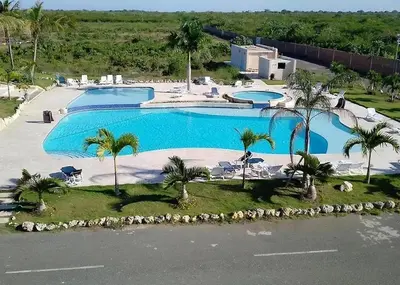 an aerial view of two swimming pools with palm trees at Modern 3-Bedroom Apartment with Pool in Boca Chica