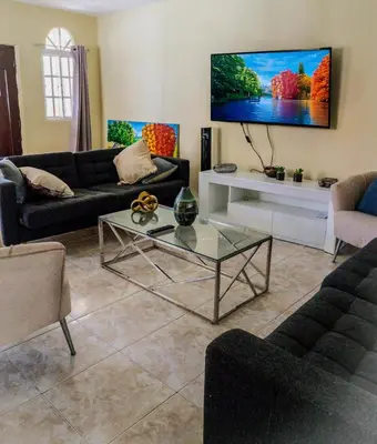 a living room with a couch and a tv at The Three Sisters Villa in Puerto Plata