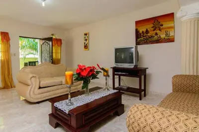 a living room with a couch and a tv at The Three Sisters Villa in Puerto Plata