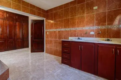 a bathroom with wooden cabinets and a sink at 3BR Villa Newly Renovated-5 min to Playa Dorada H1 in Puerto Plata