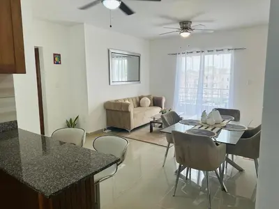 a kitchen and living room with a table and chairs at Apartamento muy cerca de la embajada Americana in Santo Domingo