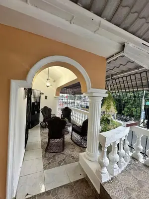 a porch with an arch with chairs and a table at Entire House in Santo Domingo Este in Los Frailes