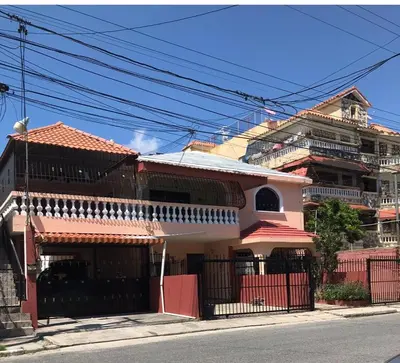 a large building with a red and white at Entire House in Santo Domingo Este in Los Frailes