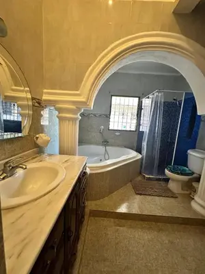 a bathroom with a tub and a sink and a toilet at Entire House in Santo Domingo Este in Los Frailes
