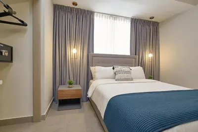 a bedroom with a large bed and a window at ®{PANO~VIEW~Experience} @DowntownSD PoolGym2BR in Santo Domingo