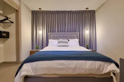 a bedroom with a large bed with purple curtains at ®{PANO~VIEW~Experience} @DowntownSD PoolGym2BR in Santo Domingo