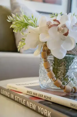 a vase with flowers and books on a table at ®{PANO~VIEW~Experience} @DowntownSD PoolGym2BR in Santo Domingo