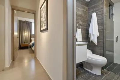 a bathroom with a toilet and a shower at ®{PANO~VIEW~Experience} @DowntownSD PoolGym2BR in Santo Domingo