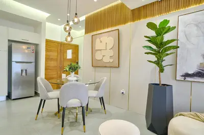 a dining room with a table and chairs and a plant at ®{Designer~City~Stay} @DowntownSD NearPark1BR in Santo Domingo