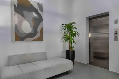 a living room with a couch and a potted plant at ®{LUX~City~Skyline} @DowntownSD PrivéJaccuziGym in Santo Domingo