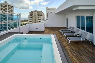 a balcony with a swimming pool on top of a building at ®{LUX~City~Skyline} @DowntownSD PrivéJaccuziGym in Santo Domingo