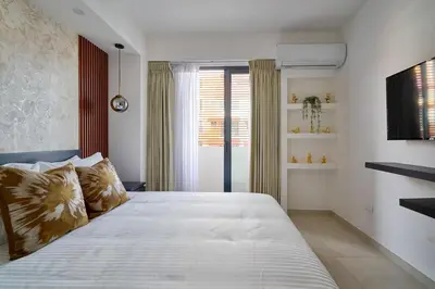 a bedroom with a large white bed and a window at ®2BR{The~City~Center}@DTown PoolGym NearCecilip in Santo Domingo
