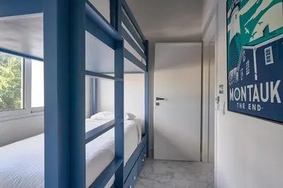 a room with a bunk bed and a door with a sign at {3BR~Beach~Condo}@LakeView PlayaBonita PoolLUX in Las Terrenas