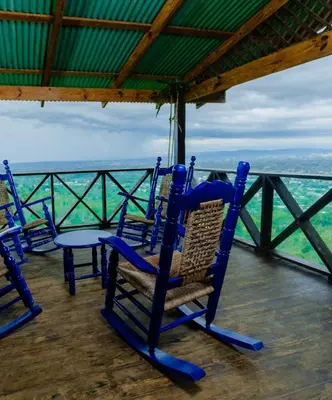 a group of chairs sitting on top of a porch at Romantic Refuge under the Stars, Villa BellaVista in Tamboril