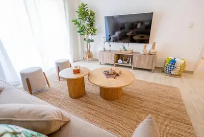 a living room with a table and a tv at Suite Boho Swim-Up | Acceso Directo. Playa Privada in Punta Cana