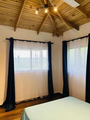 a bedroom with two windows with black curtains and a bed at Villa ana in Colorado
