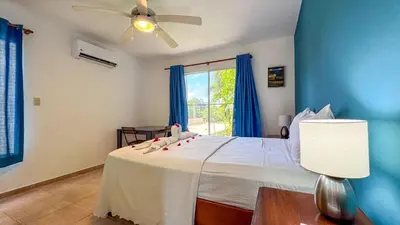 a bedroom with a white bed with a ceiling fan at Renaissance Residence Cabarete in Cabarete