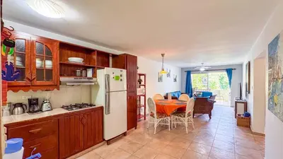 a kitchen with a table and a white refrigerator at Renaissance Residence Cabarete in Cabarete