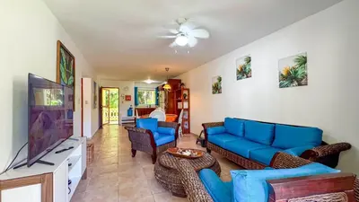 a living room with blue couches and a flat screen tv at Renaissance Residence Cabarete in Cabarete