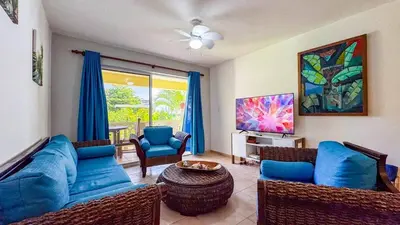 a living room with a blue couch and chairs at Renaissance Residence Cabarete in Cabarete