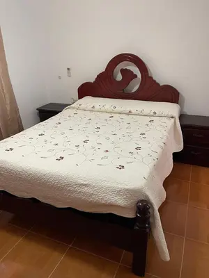 a bedroom with a bed with a wooden head board at Apartamentos España in Sosúa