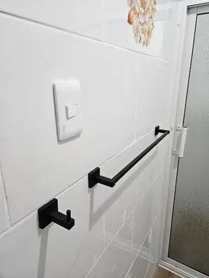 a bathroom with a white wall with a lightswitch at Eastern Breeze in Hainamosa