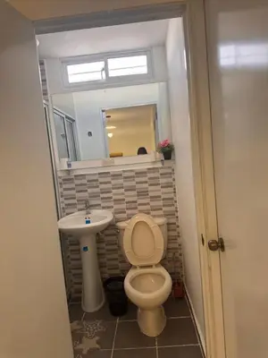 a bathroom with a toilet and a sink and a mirror at quality & comfort in Santo Domingo