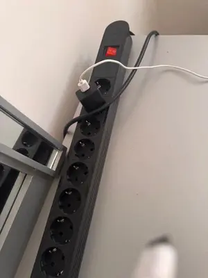 a black device with a wire plugged into a wall at quality & comfort in Santo Domingo